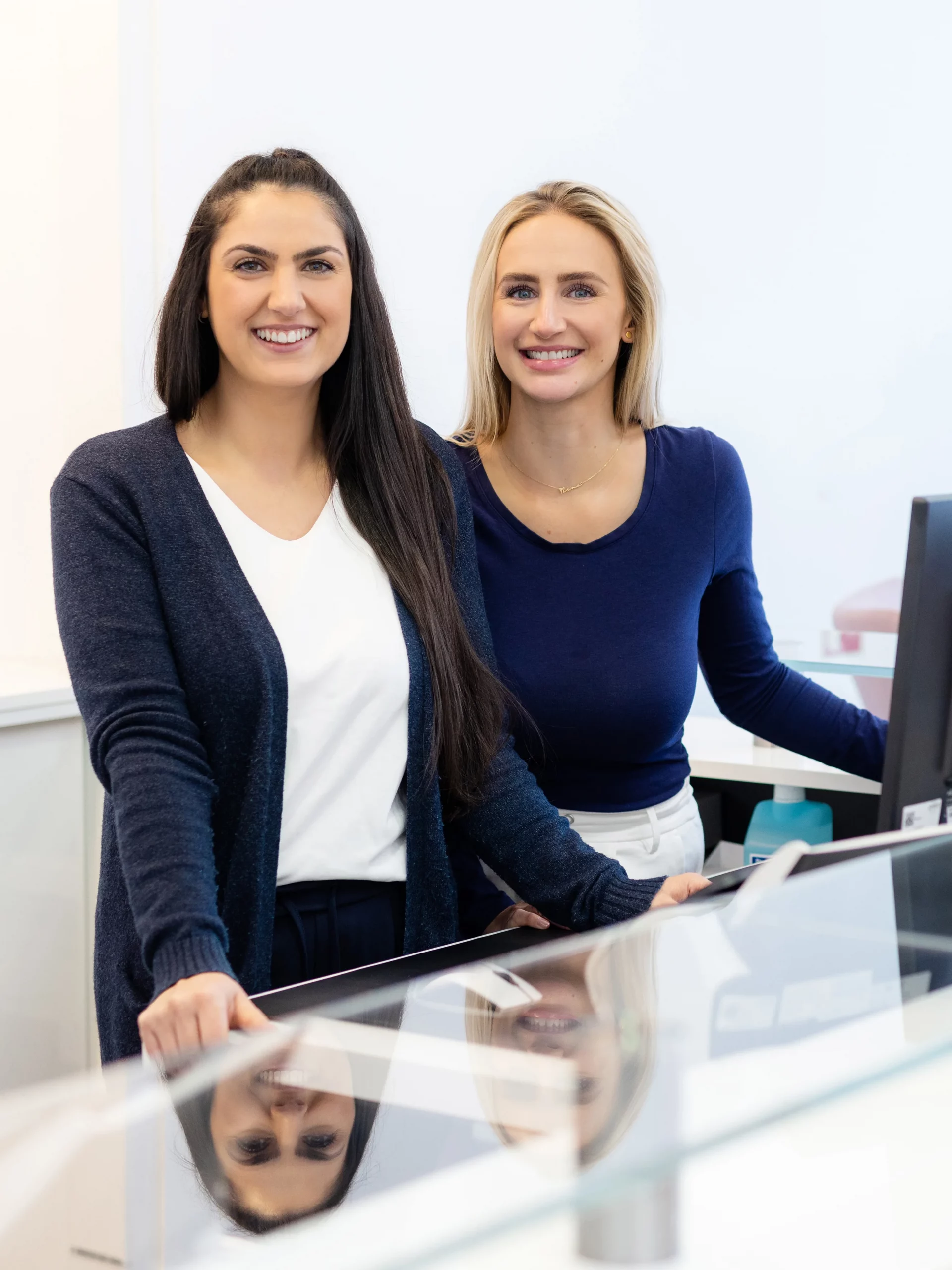 Zwei Mitarbeiterinnen stehen am Empfang der Praxis Bergmannstraße.